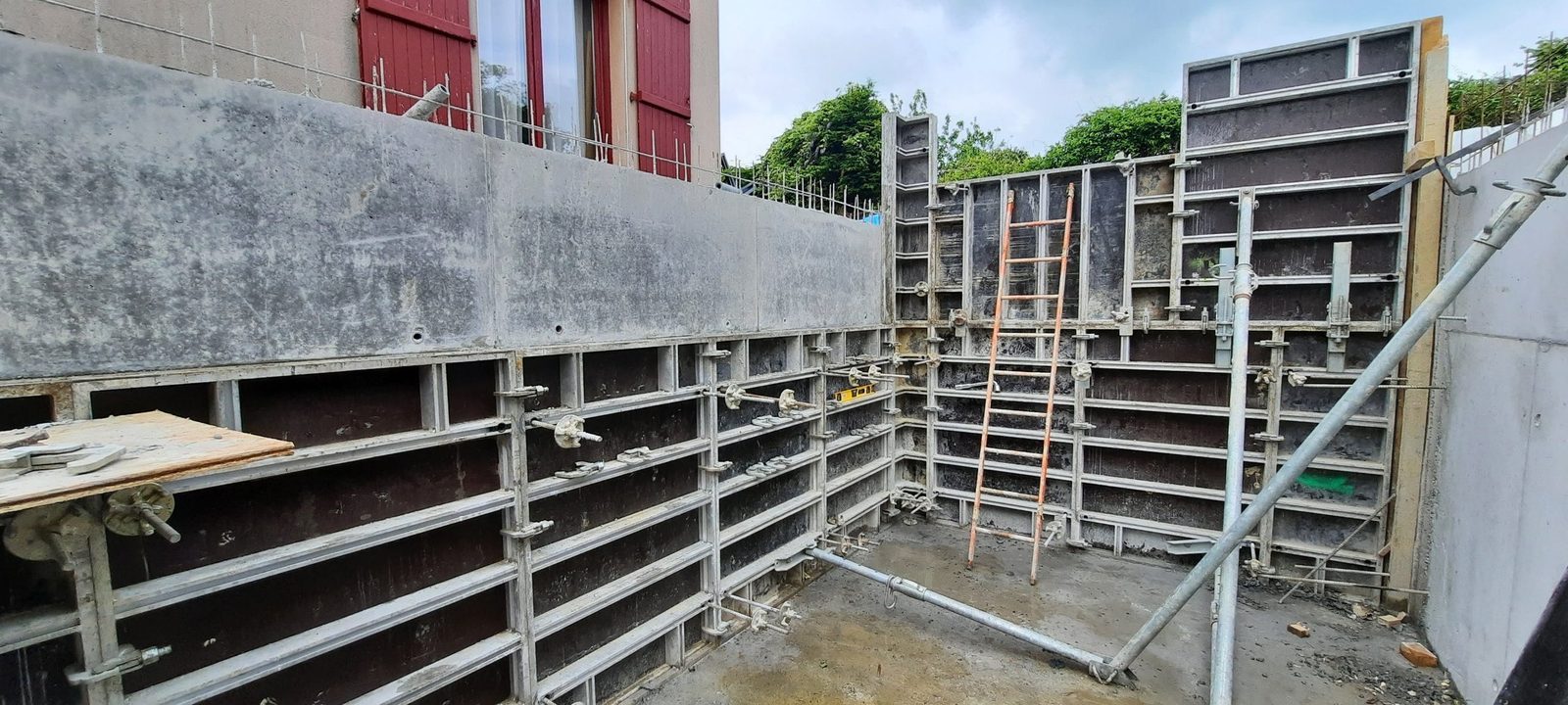 Banches métalliques en place pour couler des voiles en béton armé, voile décoffré au-dessus