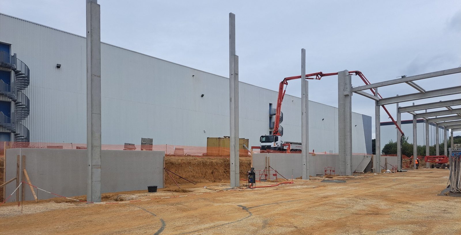 Murs de soutènement en béton armé réalisés par AMC Construction sur le chantier Mobilitas, bétonnage à la pompe en arrière-plan