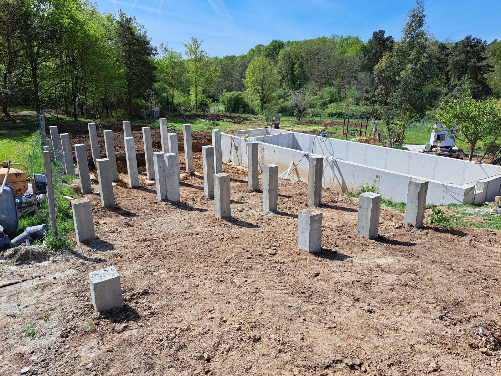 Massifs et poteaux béton pour l'extension en ossature bois, piscine en arrière-plan